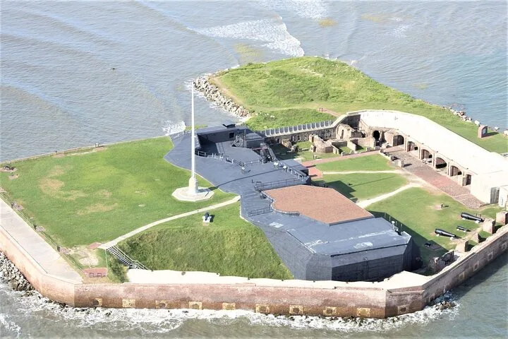 Vue aérienne d'un fort historique en briques avec des zones herbeuses et des canons.
